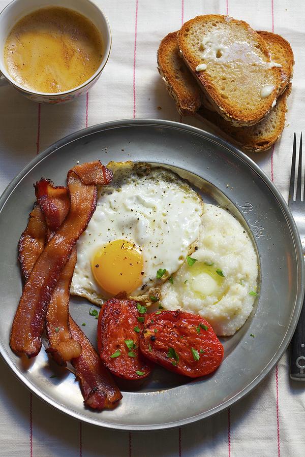 Breakfast; Eggs, Bacon, Grits, Stewed Tomatoes And A Side Of Toast With Coffee Photograph by Jennifer Martine