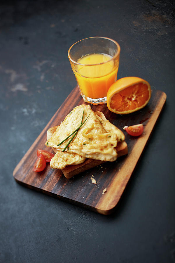 Breakfast With Scrambled Eggs On Toast And A Glass Of Freshly Pressed Orange Juice Photograph by Rafael Pranschke