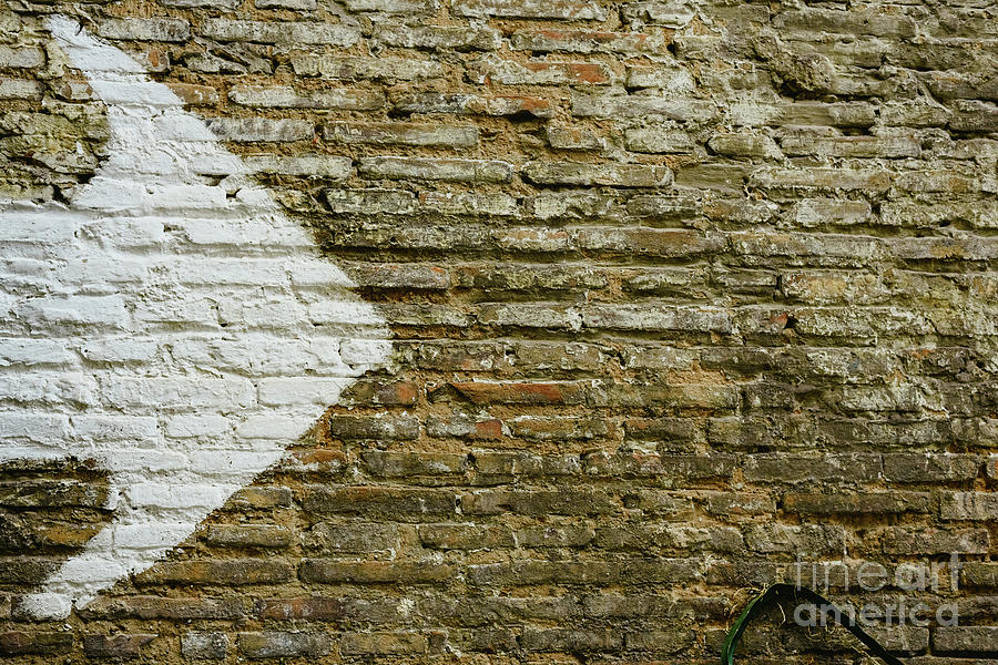 Brick wall with big white arrow indicating direction, background with copy space. Photograph by Joaquin Corbalan