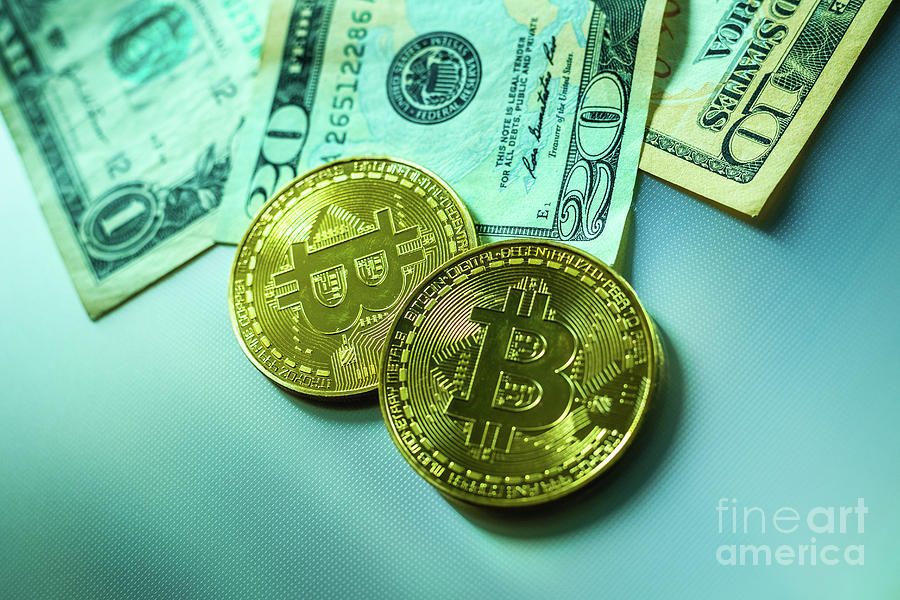 Bright bitcoin coins next to dollar bills. Photograph by Joaquin Corbalan