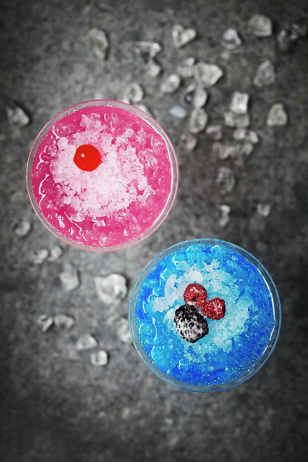 Bright Blue And Pink Frozen Cocktails Topped With Berries And Maraschino Cherries Photograph by Charlotte Tolhurst