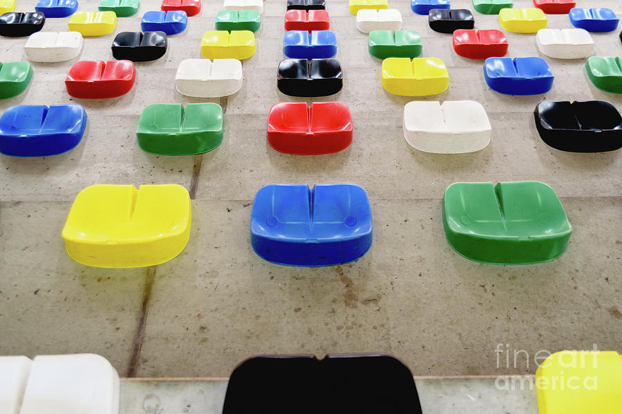Brightly colored plastic seats without anyone sitting in a sport Photograph by Joaquin Corbalan