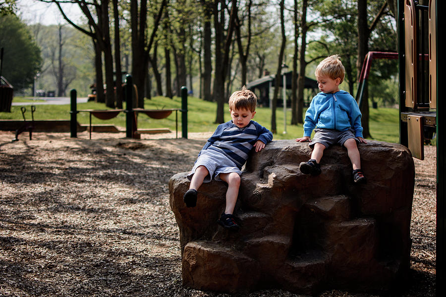 Nature Photograph - Brothers Sitting On Rock In Playground by Cavan Images
