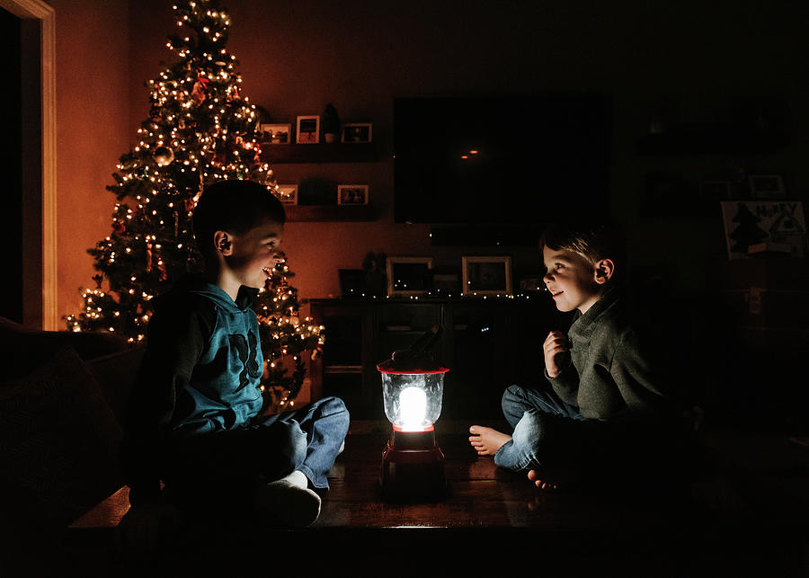 Christmas Photograph - Brothers With Illuminated Lantern Sitting By Christmas Tree At Home by Cavan Images