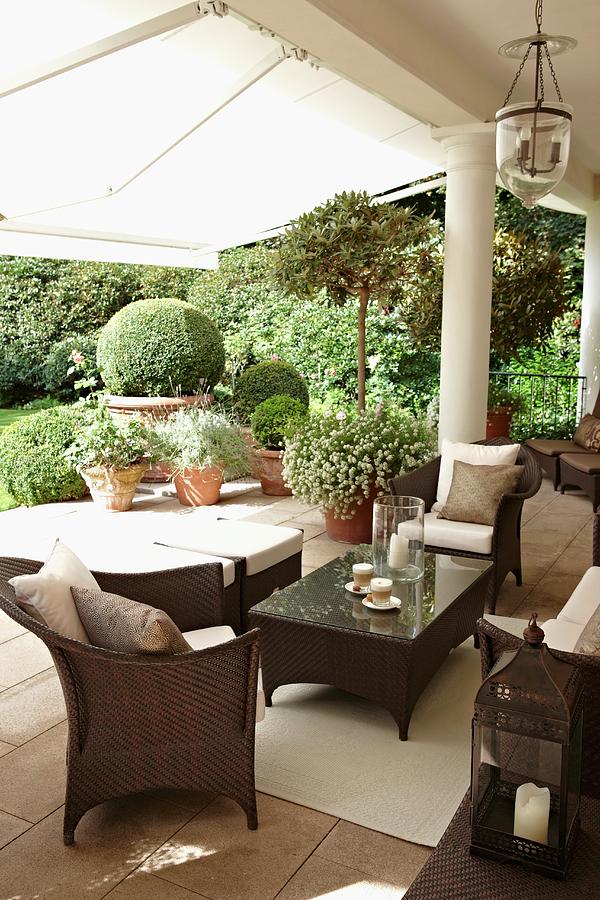 Brown Rattan Outdoor Furniture On A Traditional Terrace With Columns And White Awning; View Of The Garden Photograph by Misha Vetter