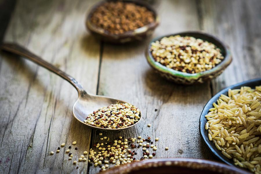 Brown Rice, Quinoa And Buckwheat On A Wooden Surface Photograph by Alena Haurylik