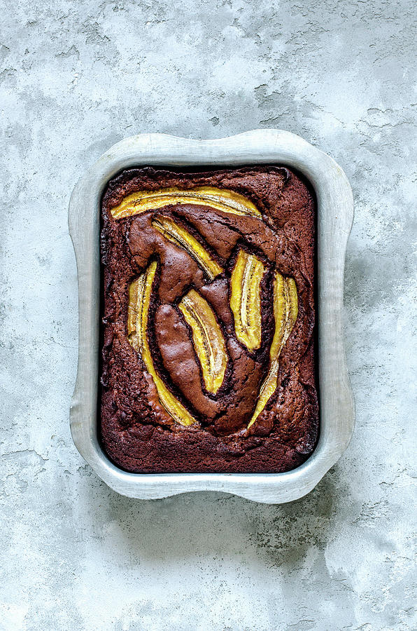 Brownie With Milk Chocolate, Bananas And Sea Salt In Aluminum Form On A Concrete Surface Photograph by Gorobina