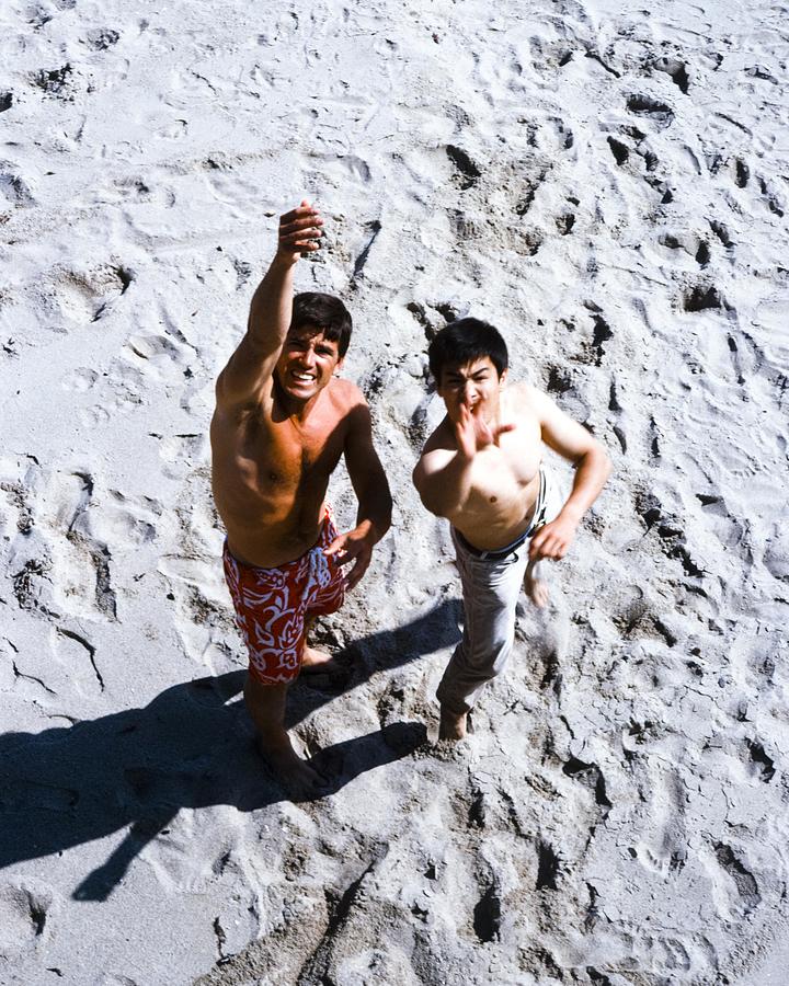 Bruce Lee Photograph - Bruce Lee Standing With Van Williams On Beach by Globe Photos