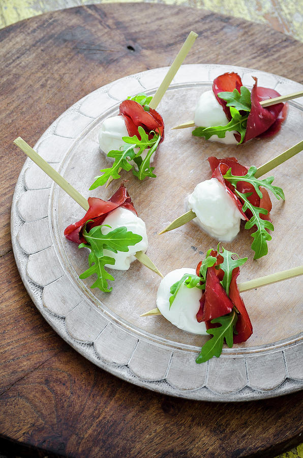 Buffalo Mozzarella Bites With Bresaola And Fresh Rocket Leaves Canapes On A White Wooden Board And Wooden Background Photograph by Giulia Verdinelli Photography