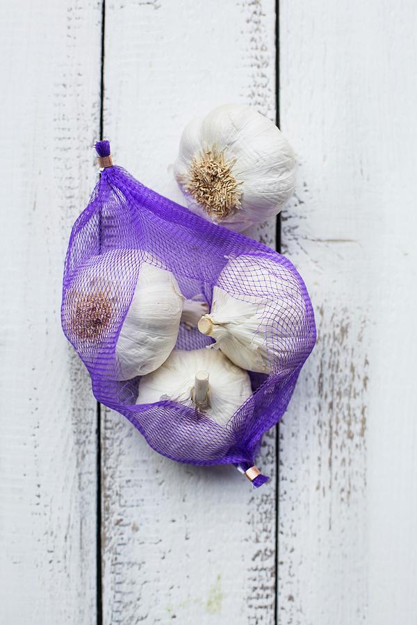 Bulbs Of Garlic In A Net Photograph by Sabine Steffens