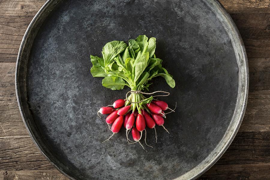 Bunch Of Radishes Ties With String On A Grey Metal Tray On A Wooden Table Photograph by Sarah Coghill