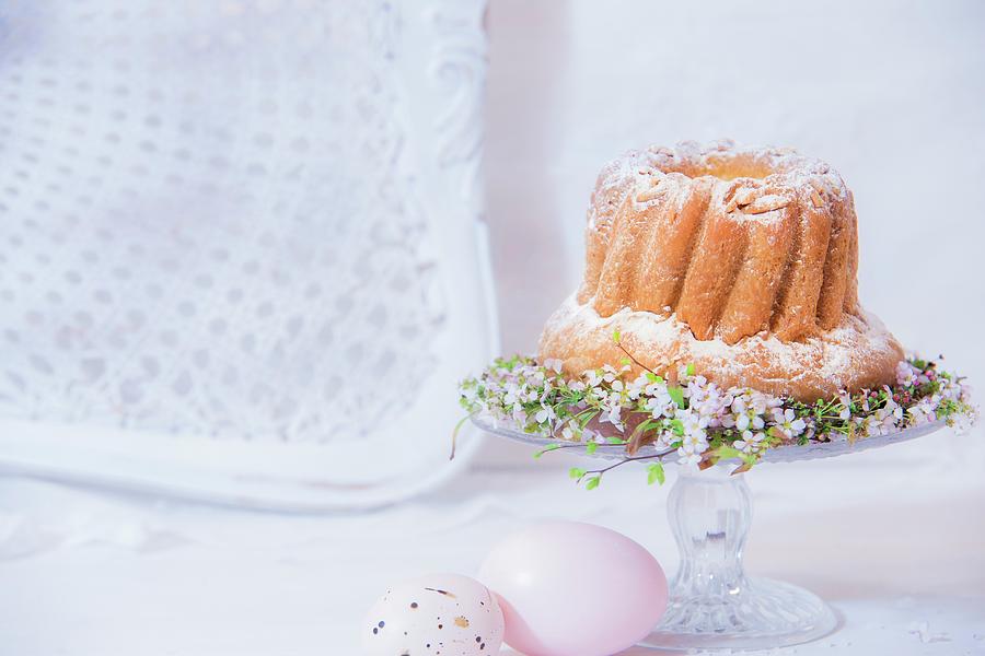 Bundt Cake On Decorated Cake Stand Next To Easter Eggs Photograph by Bildhbsch