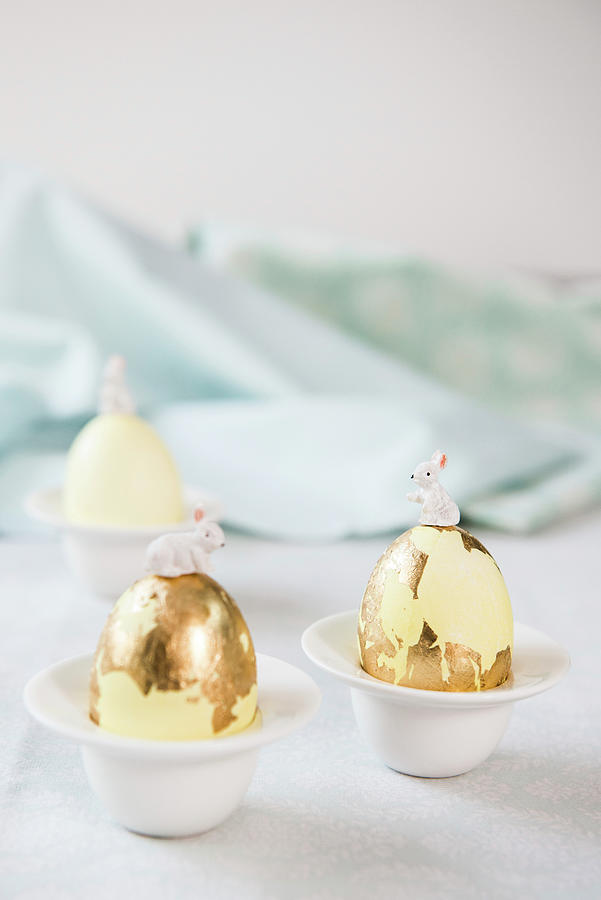 Bunnies On Top Of Easter Eggs Covered In Gold Leaf Photograph by Ruud Pos