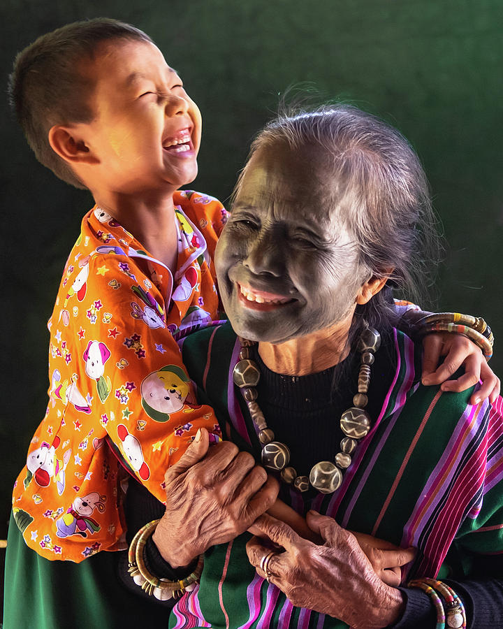 Burmese woman laughing with her granddaughter Photograph by Ann Moore
