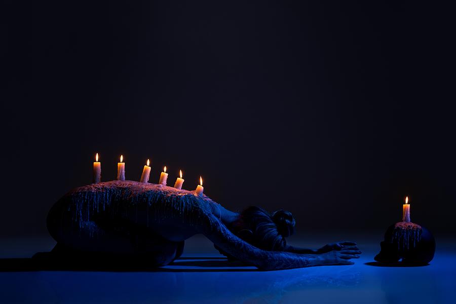 Skull Photograph - Burning Candles On Back Of Lady Bowing Down In Darkness by Andrey Guryanov