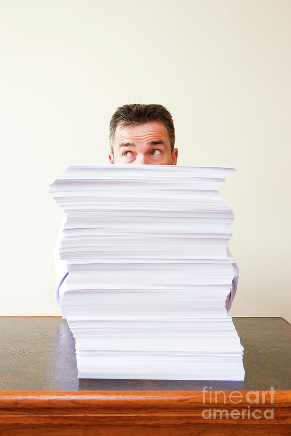 Businessman Behind Stack Of Papers Photograph by Conceptual Images/science Photo Library