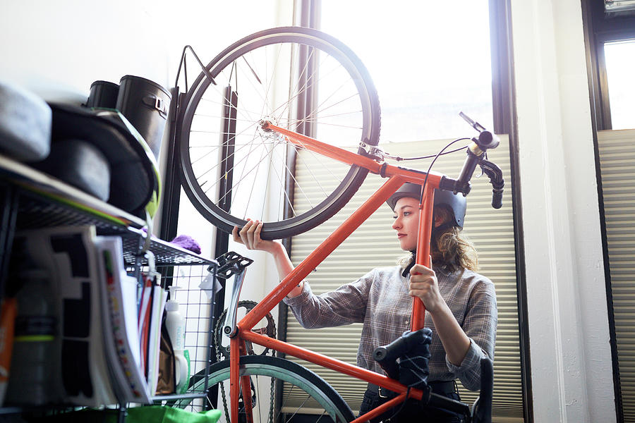 Transportation Photograph - Businesswoman Removing Bicycle From Rack In Creative Office by Cavan Images