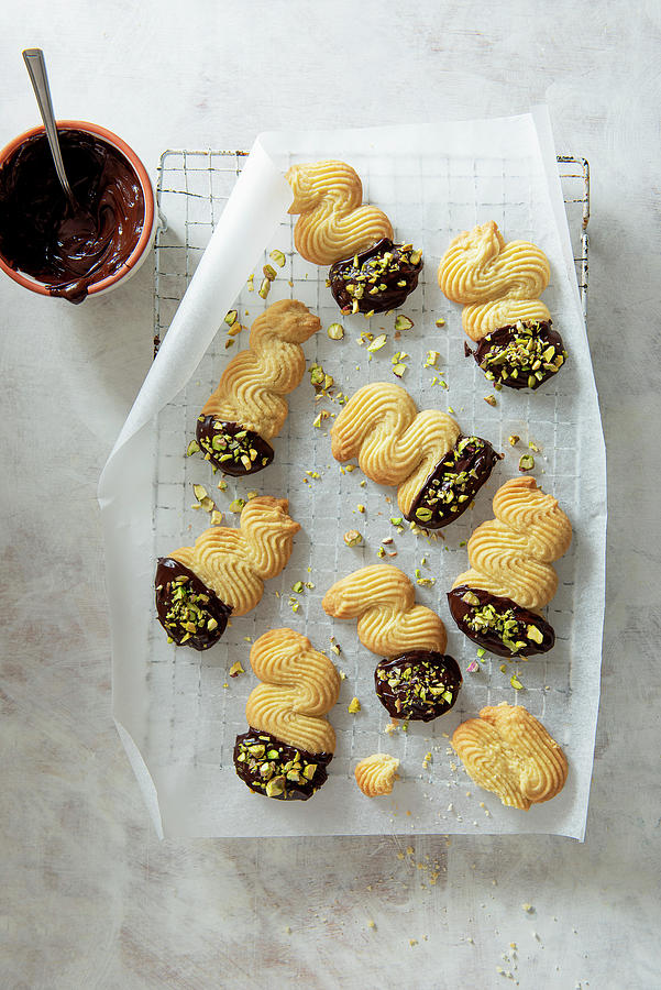Butter Biscuits Dipped In Dark Chocolate And Sprinkled With Pistachios Nuts On A Cooling Rack Photograph by Magdalena Hendey