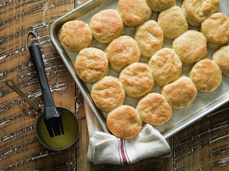 Buttermilk Biscuits On A Baking Tray With Melted Butter And A Bakers Brush Photograph by Don Crossland