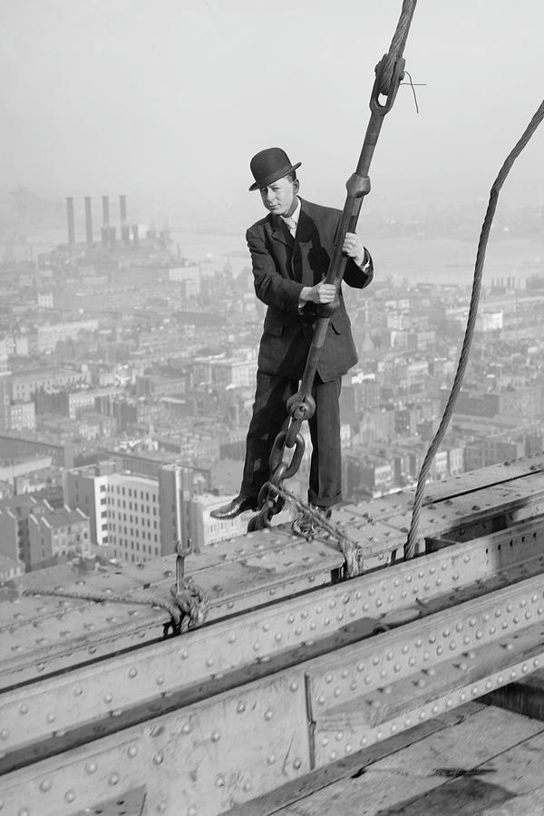 Cameraman in suit holds onto cable as he walks unharnessed over a skyscrapers steel girders Painting by Wilbur Pierce