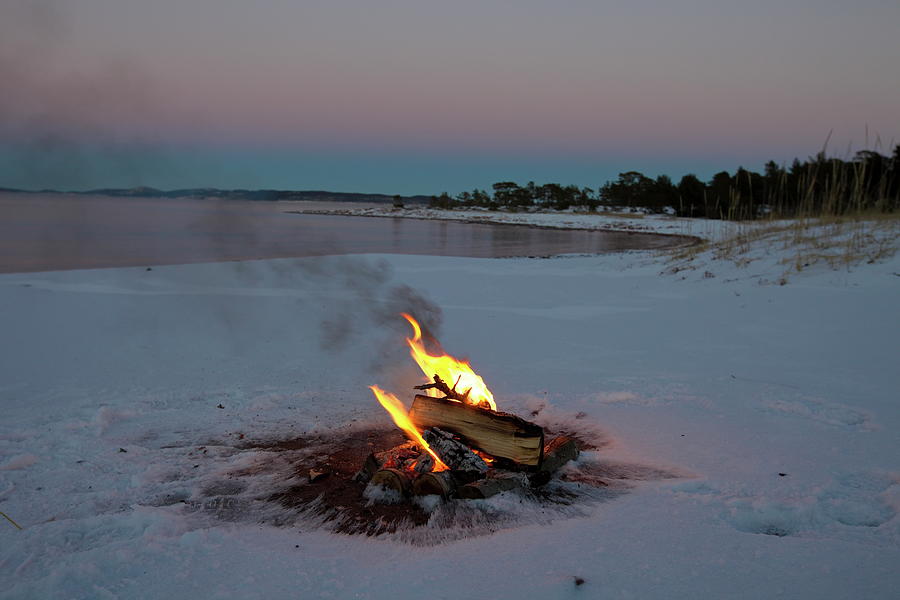 Camp fire in the snow on a beach Photograph by Intensivelight
