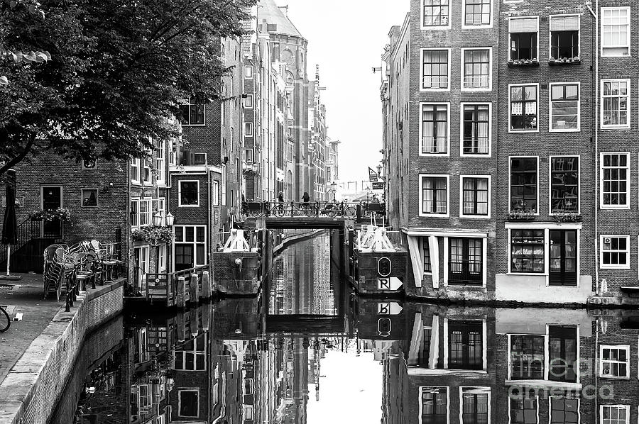 Canal Between the Buildings in Amsterdam Photograph by John Rizzuto