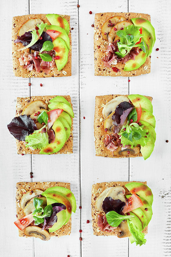 Canapes With Mushrooms, Avocado, Salad, Prosciutto On Bread Crouton With Seeds, White Wooden Background Photograph by Corina Daniela Obertas