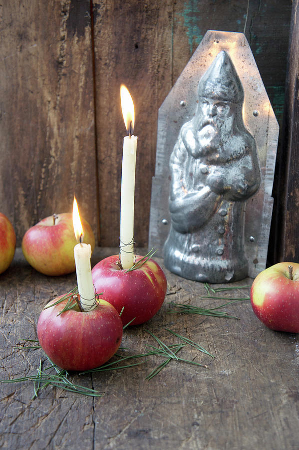 Candles In Red Apples In Front Of Chocolate Mould Photograph by Martina Schindler