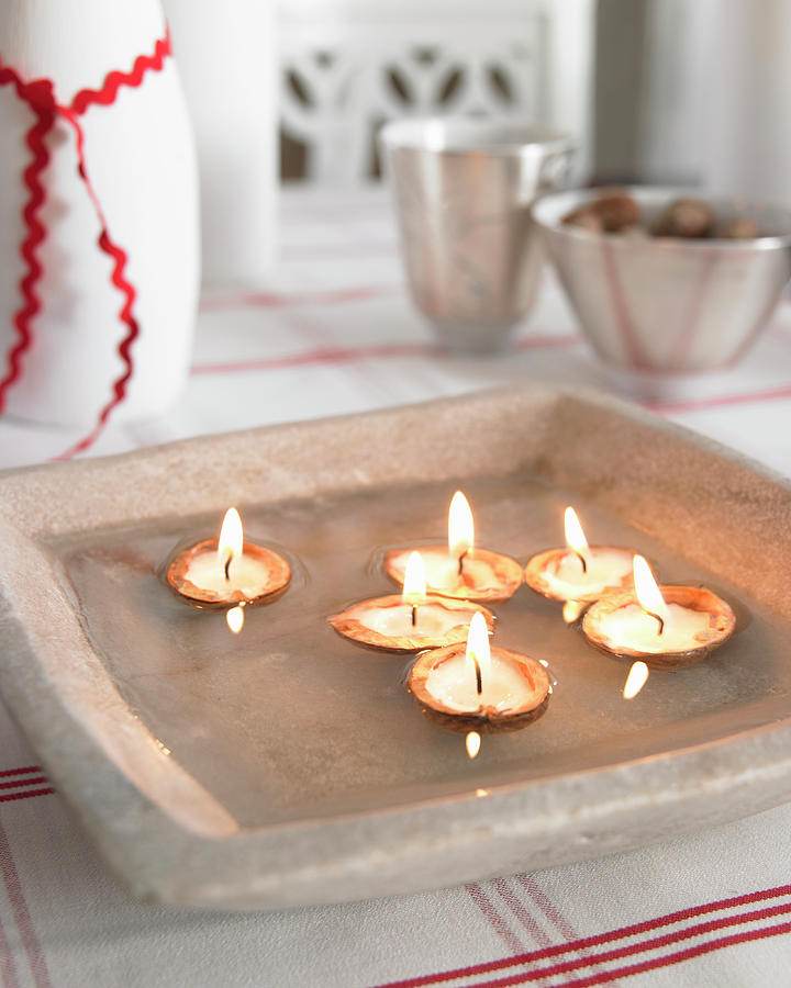 Candles In Walnut Shells Floating In Grey Dish Photograph by Medri - Szczepaniak