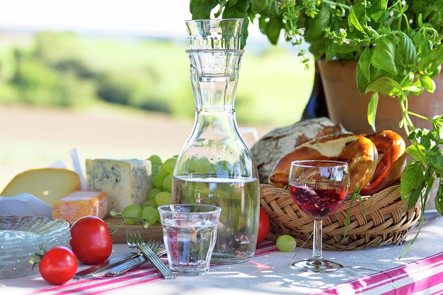 Carafe Of Water, Bread Basket, Cheese And Grapes On Set Picnic Table Photograph by Angela Francisca Endress
