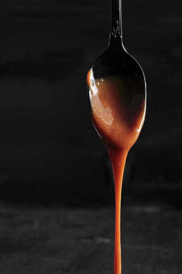 Caramel Dripping From A Spoon Photograph by Garten, Peter