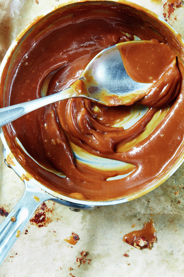Caramel Sauce In A Saucepan With A Spoon Photograph by Leigh Beisch