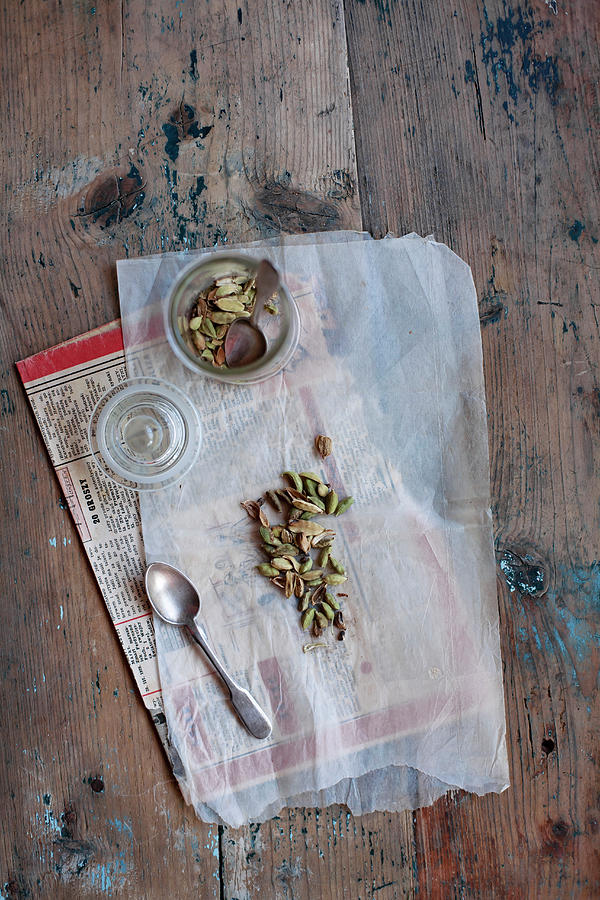 Cardamom On Translucent Baking Parchment And Newspaper Photograph by Alicja Koll