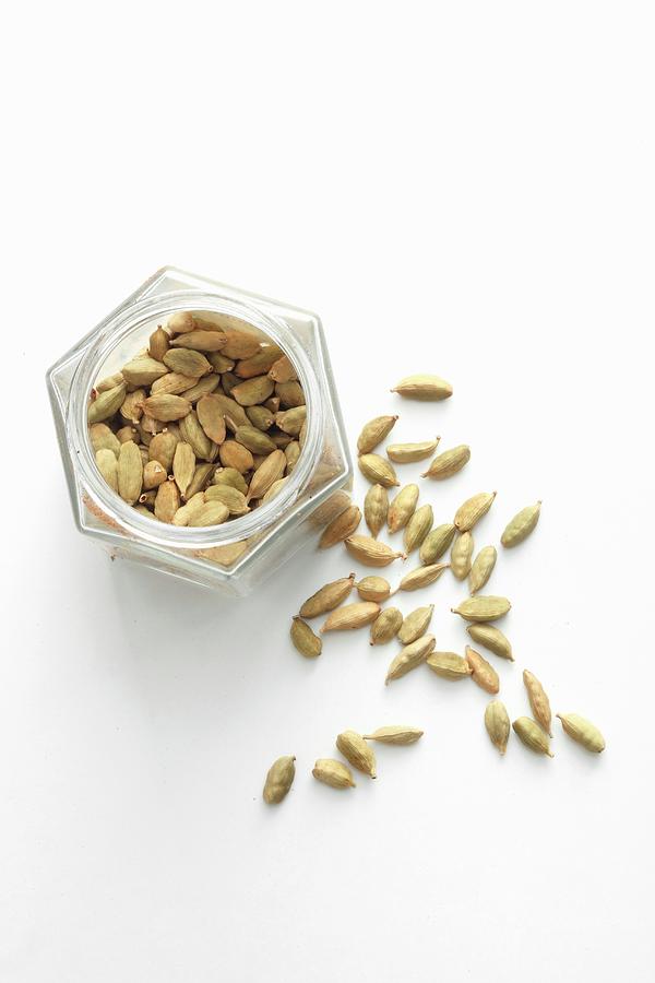 Cardamom Pods In A Jar And Next To It Photograph by Jalag / Mathias Neubauer