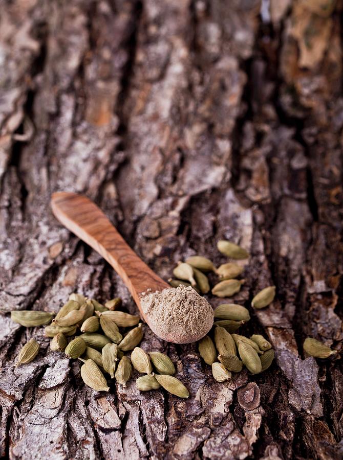Cardamom, Whole Pods And Ground, With A Wooden Spoon On A Piece Of Bark Photograph by Dorota Indycka
