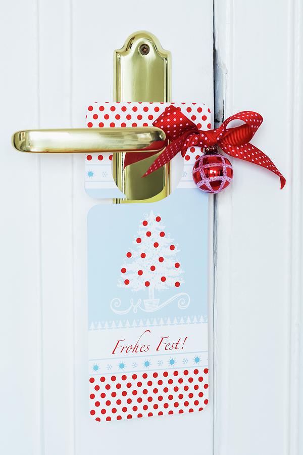 Cardboard Christmas Door Sign, Red Bauble And Bow On Brass Door Handle Photograph by Franziska Taube