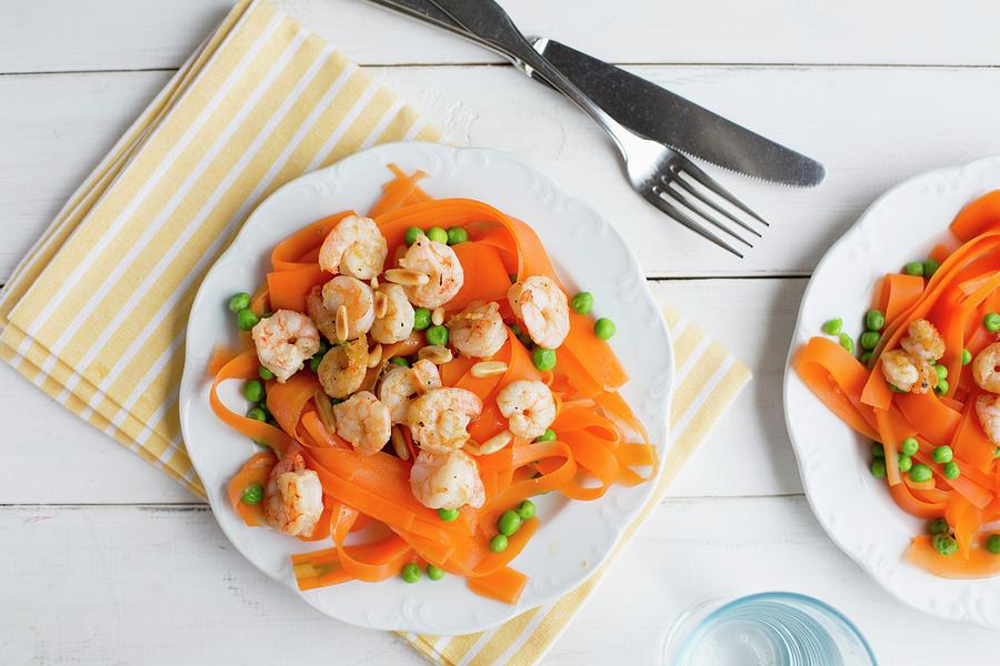 Carrot Tagliatelle With Prawns, Peas And Pine Nuts Photograph by Claudia Timmann