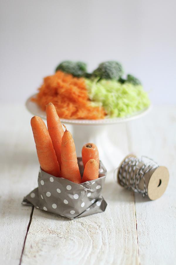 Carrots In A Paper Bag With A Pile Of Grated Vegetables In The Background Photograph by Sylvia E.k Photography
