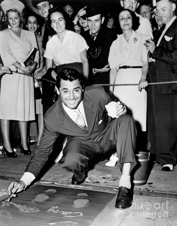 Cary Grant Signing Concrete Slab Photograph by Bettmann