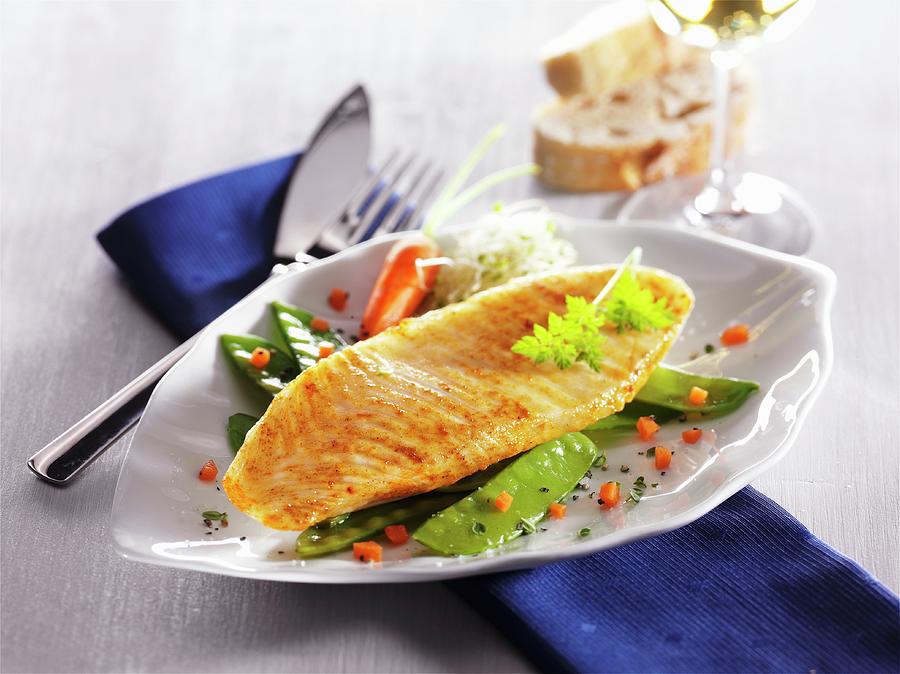 Catfish Fillet On A Bed Of Mange Tout And Carrots On A Ceramic Plate Photograph by Christian Schuster
