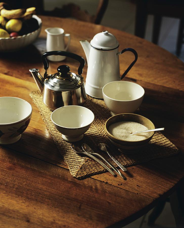Ceramic Bowls, A Kettle And An Enamel Jug On A Wooden Table Photograph by Chris Tubbs