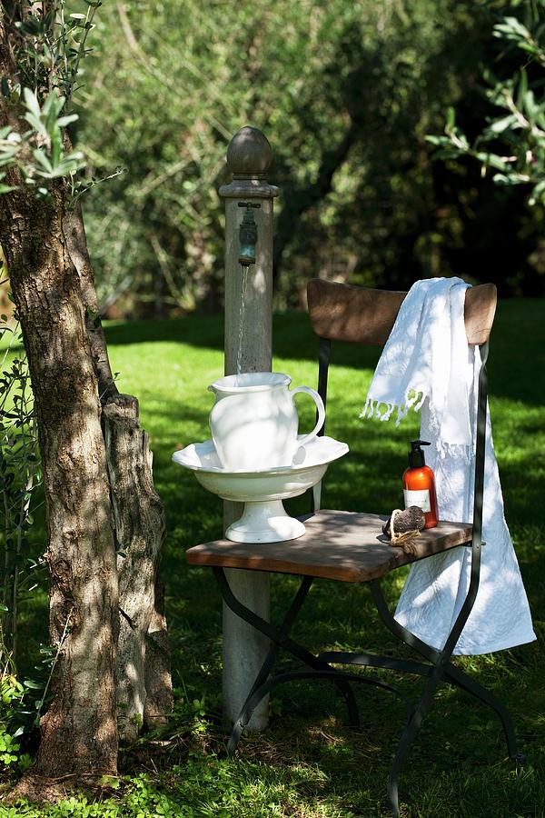Ceramic Washbasin And Jug On Chair In Garden Photograph by Christophe Madamour