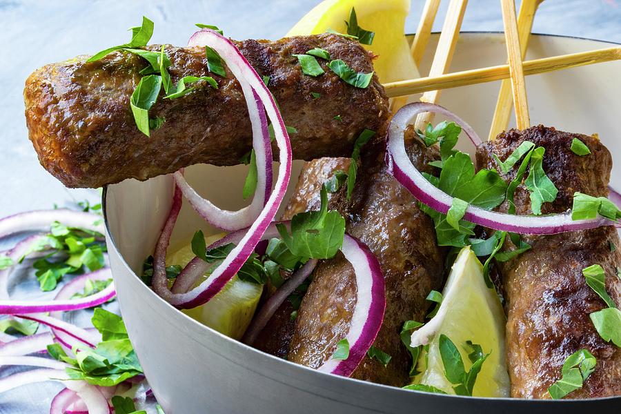 Cevapcici On Wooden Skewers With Onions, Parsley And Lemon In A Grey Bowl Photograph by Charlotte Von Elm