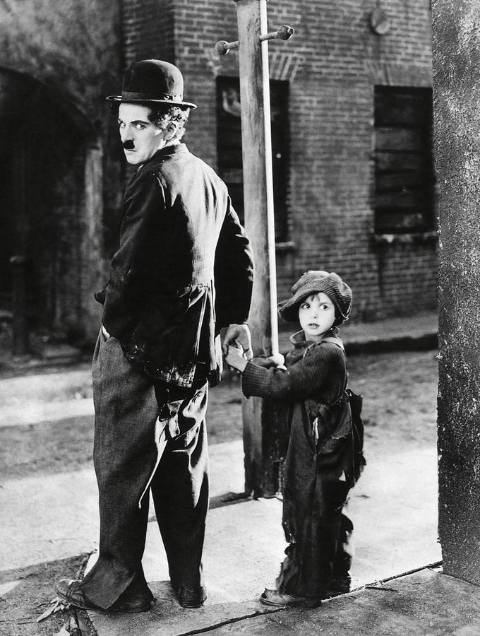 CHARLIE CHAPLIN and JACKIE COOGAN in THE KID -1921-. Photograph by Album