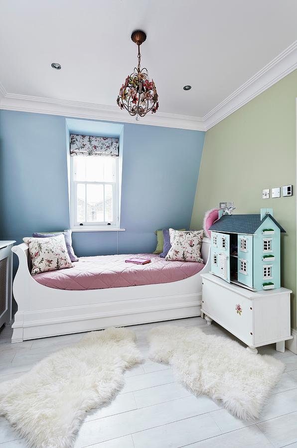Cheerful Childs Bedroom With Large Dolls House And Soft Animal-skin Rugs On Floor Next To Bed Photograph by Simon Maxwell Photography