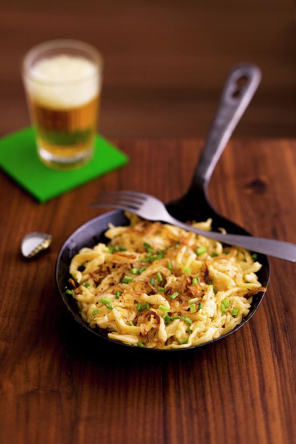 Cheese Sptzle soft Egg Noodles From Swabia In A Pan With A Glass Of Beer In The Background Photograph by Michael Wissing