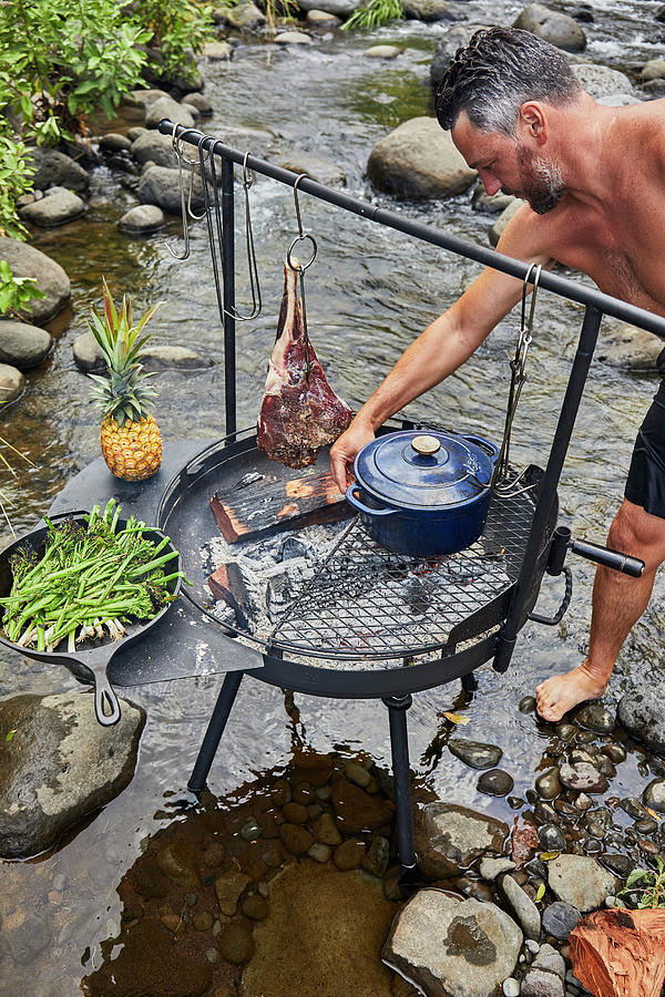 Barbecue Over Wood Fired Grill Near Stream by Cavan Images