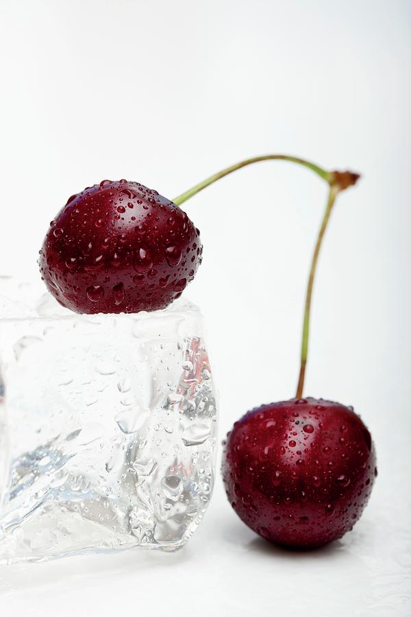 Cherries And An Ice Cube Photograph by Creative Photo Services