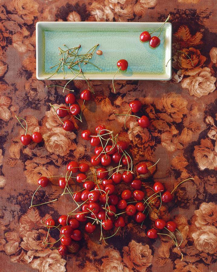 Cherries On The Stalk On A Plate And On A Floral Tablecloth view From Above Photograph by Michael Wissing