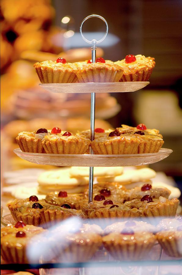 Cherry Frangipane Cakes In The Window Of A Bakery Photograph by Jamie Watson